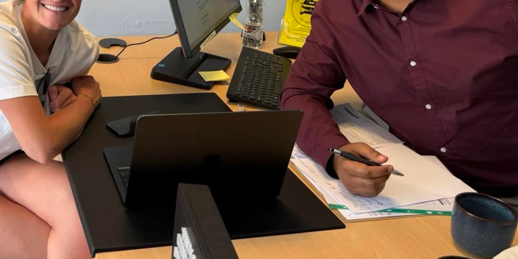 Laptop, keyboard and tax paperwork on a desk